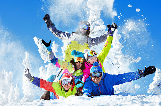 Una famiglia sorridente posa per una foto di gruppo con slitta in mezzo alla neve