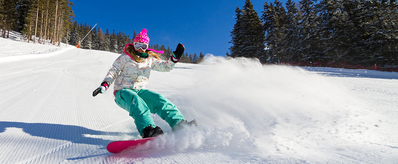Una ragazza pratica snowboard sulle piste di Plan de Corones